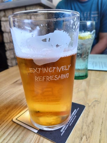 Extinctively refreshing beer from Portland with T-rex skull on glass