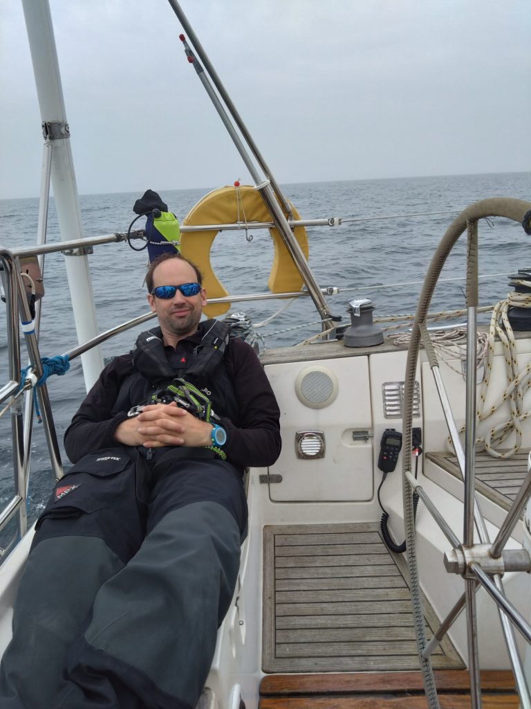 Mike lounging on cockpit seats behind the wheel with yellow horseshoe behind him