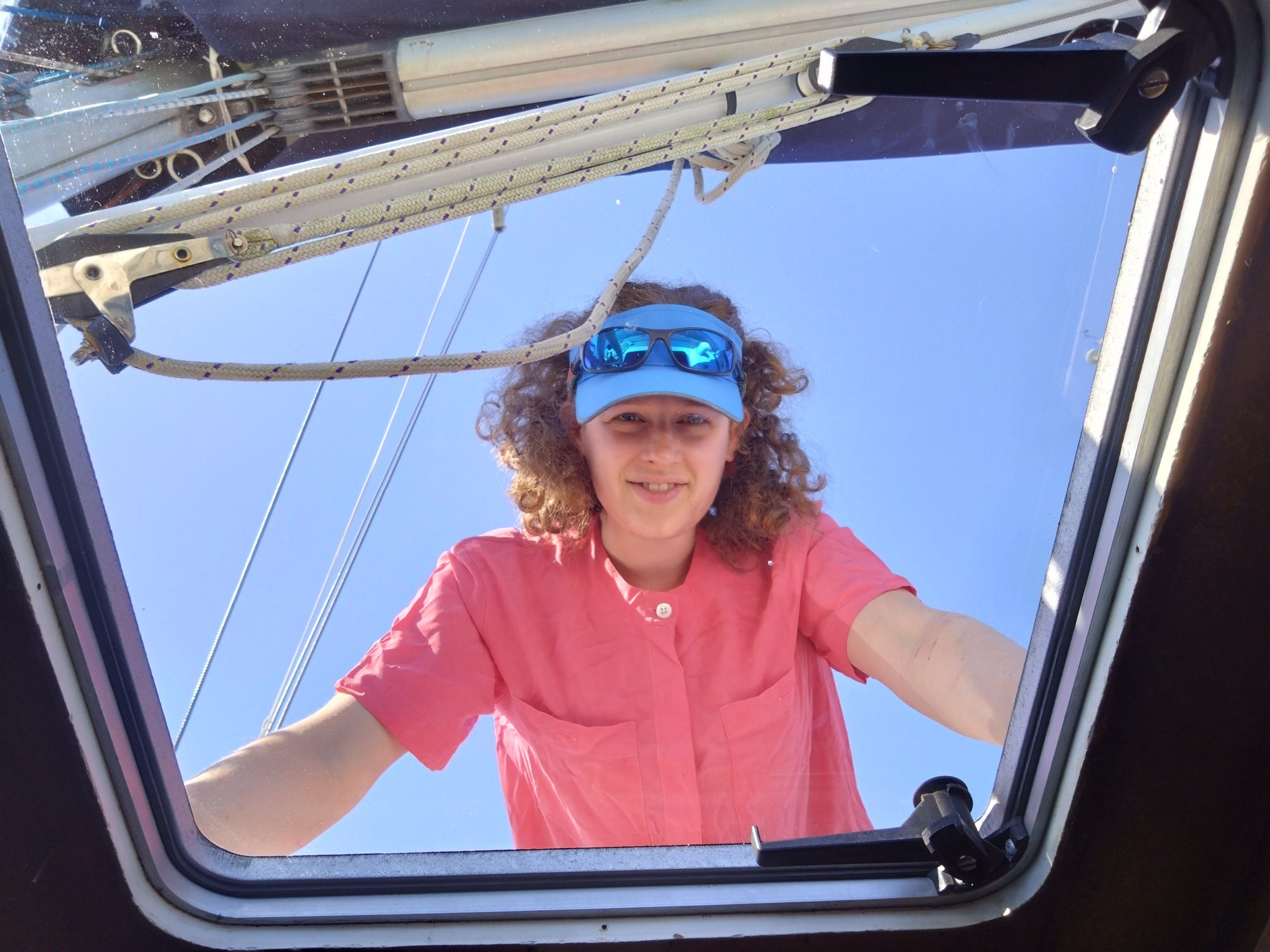 Looking up through clear new hatch to see person in pink shirt